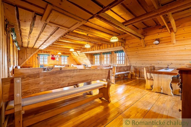 Innenraum eines Einfamilienhauses mit Holzwänden, Bänken und einem Boden mit Holzdekor.