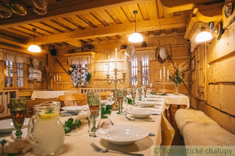 Festlich gedeckter Tisch im Inneren eines Einfamilienhauses mit Holzelementen und Kerzenhaltern.