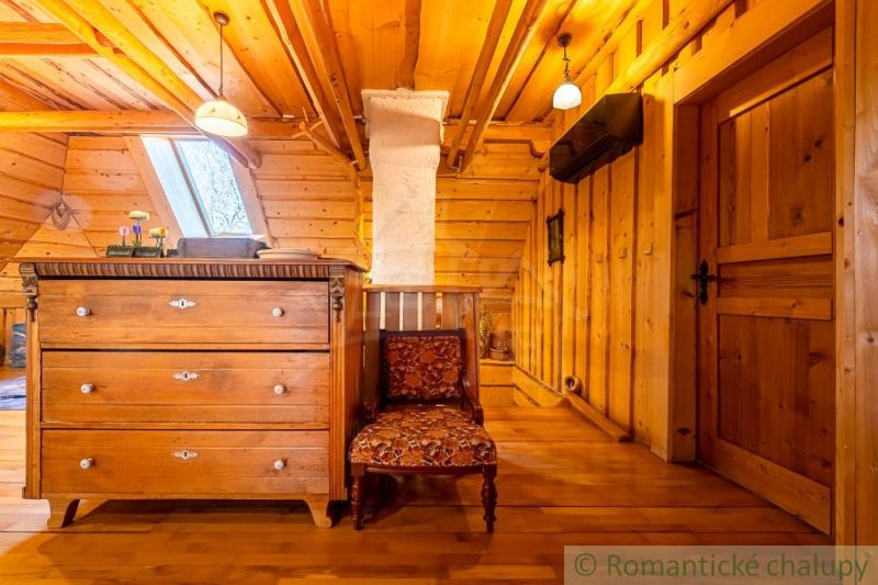 Dachboden eines Einfamilienhauses mit einem Schrank, einem Sessel und einem Boden mit Holzdekor.