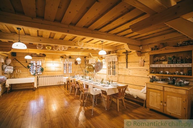 Innenraum eines Einfamilienhauses mit Holzboden, gedeckten Tischen und Holzmöbeln.