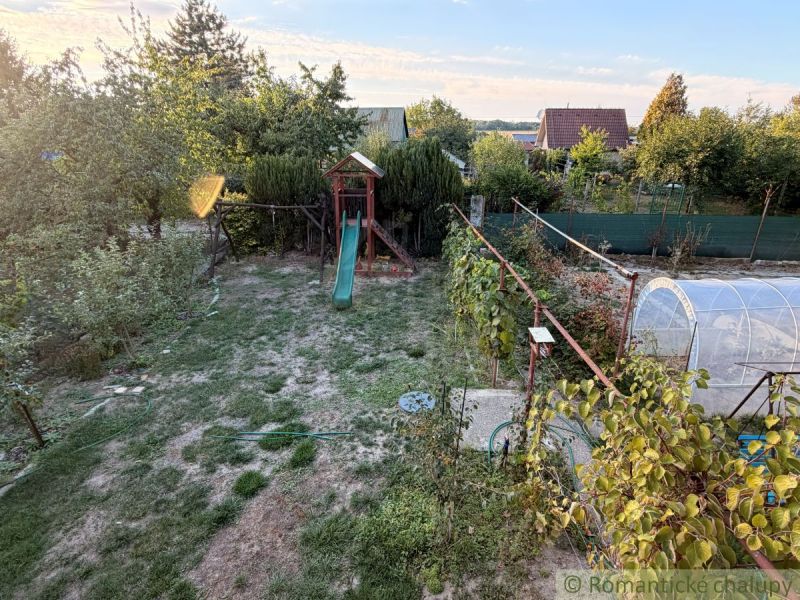 Garten mit Rasen und Rutsche bei einer Hütte in Nové Zámky.