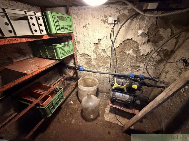 Lagerraum mit Regalen und Plastikboxen in der Hütte.