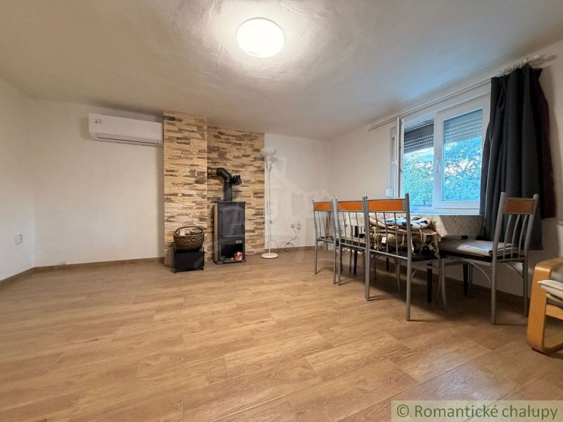 Ein Interieur einer Hütte mit Holzboden, Kamin und Essecke.