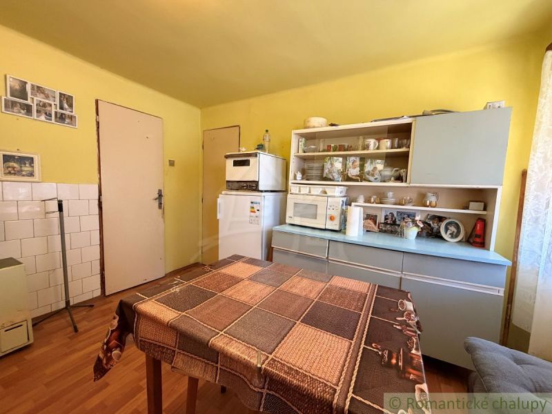Eine Küche in einem Einfamilienhaus mit einem Holzboden und älteren Möbeln.