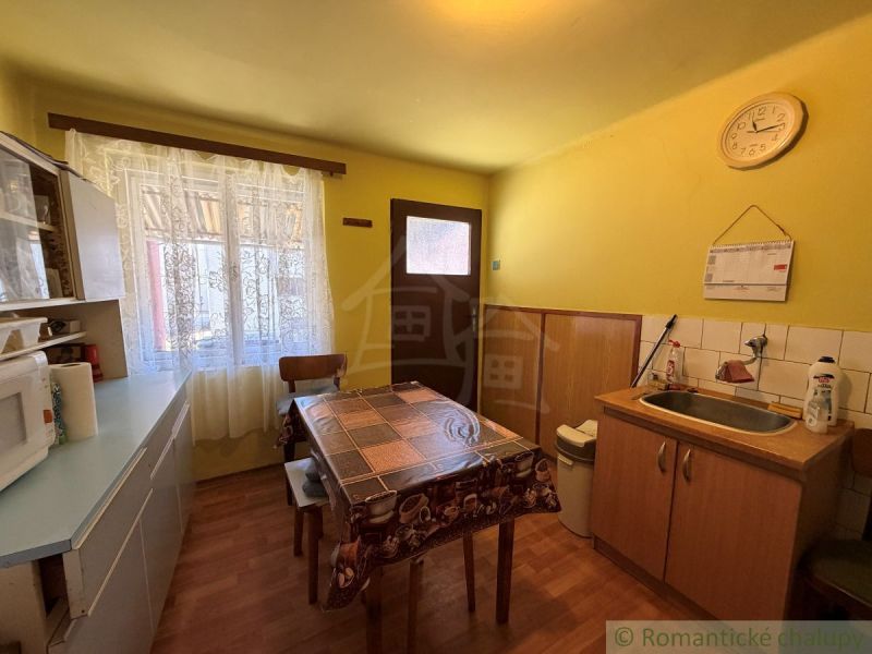 Küche in einem Einfamilienhaus mit Holzboden und gelben Wänden.