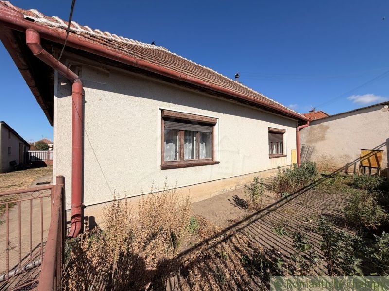 Ein Einfamilienhaus in Hurbanovo mit weißer Fassade, braunen Fensterläden und einem Garten hinter dem Haus.