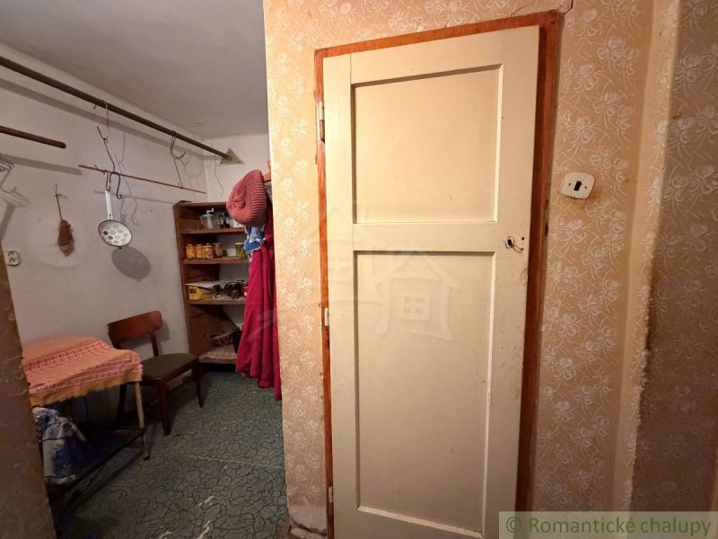 Interieur eines Einfamilienhauses mit Flur, Stuhl und Regalen. Hier hängen Küchenwerkzeuge.