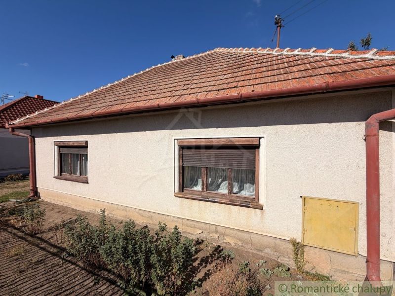 Ein Einfamilienhaus in Hurbanovo mit weißer Fassade und Schrägdach auf einem sonnigen Grundstück.