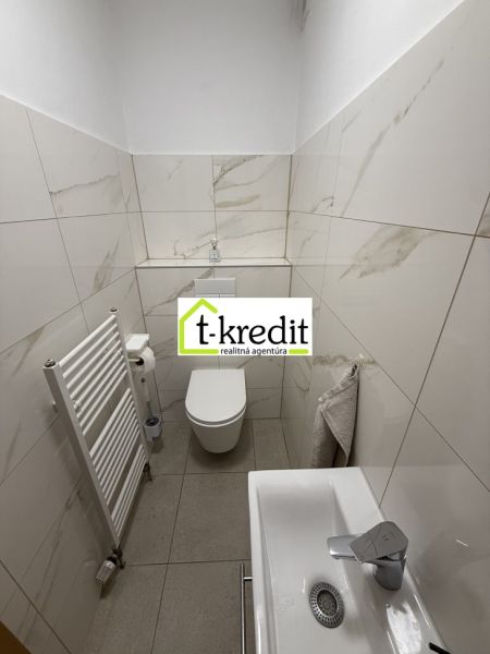 Badezimmer in einem Einfamilienhaus mit weißen Fliesen und Waschbecken.