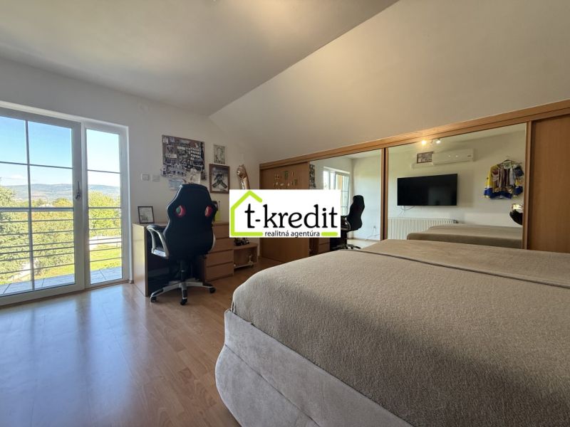Schlafzimmer in einem Einfamilienhaus mit Holzboden, Spiegelschrank und Balkontüren.