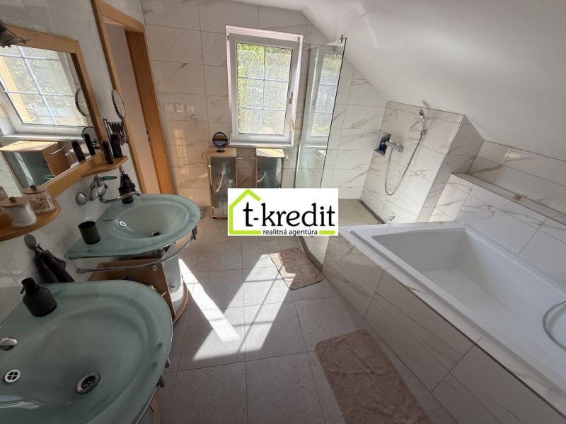 Ein Badezimmer in einem Einfamilienhaus mit zwei Waschbecken, einer Badewanne und einer Dusche.