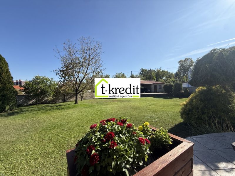 Der Garten des Einfamilienhauses in Zlaté Moravce mit blühenden Blumen und Bäumen.