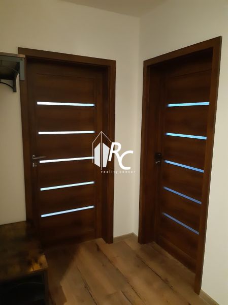 Zwei Holztüren und ein Boden mit Holzdekor in einer 2-Zimmer-Wohnung.