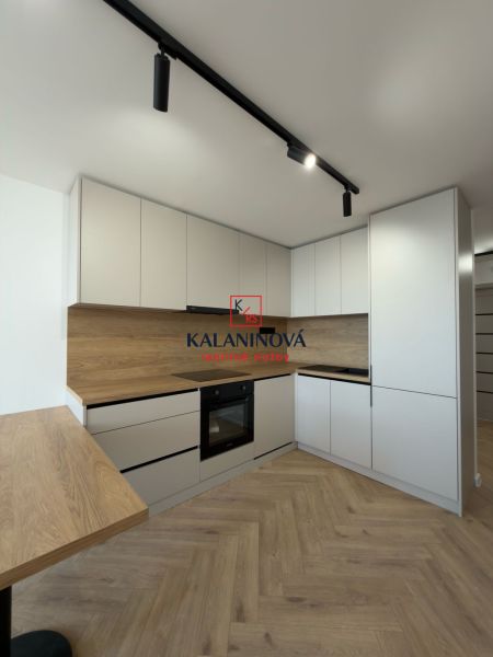 Küche in einer 4-Zimmer-Wohnung mit Holzboden und modernen Schränken.