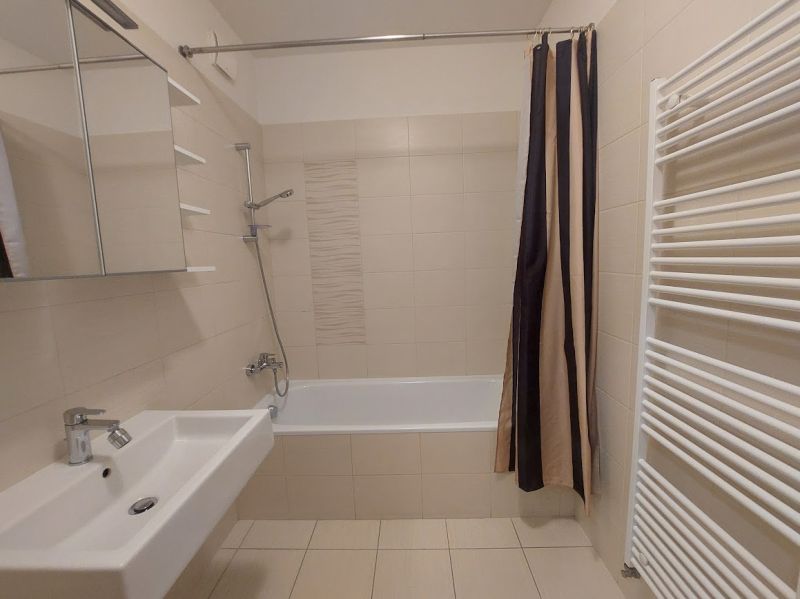 Badezimmer in einer 3-Zimmer-Wohnung mit Badewanne, Waschbecken und Handtuchheizkörper.