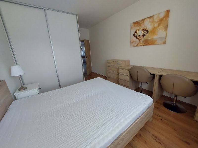 Schlafzimmer mit Holzboden, Bett, Schreibtisch und Kleiderschränken in einer 3-Zimmer-Wohnung.