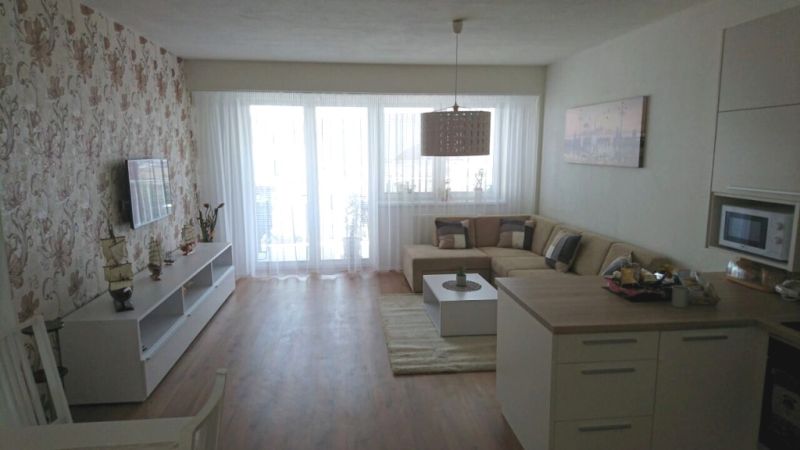 Wohnzimmer in einer 3-Zimmer-Wohnung mit Holzboden und Blumenklebeband.