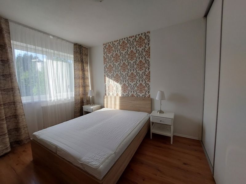 Schlafzimmer mit Bett, Tapete und Holzboden in einer 3-Zimmer-Wohnung.