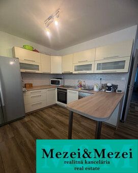 Küche mit hellen Schränken und Holzboden in einer 2-Zimmer-Wohnung.