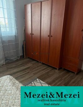 Ein Zimmer in einer 2-Zimmer-Wohnung mit Schränken und einem Boden in Holzoptik.