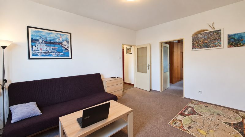 Wohnzimmer in einer 3-Zimmer-Wohnung mit Sofa, Couchtisch und Bildern an der Wand.