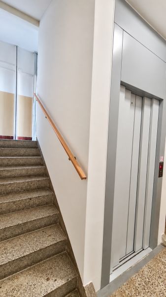 Treppenhaus mit Geländer und Aufzug im Gebäude bei einer 3-Zimmer-Wohnung.
