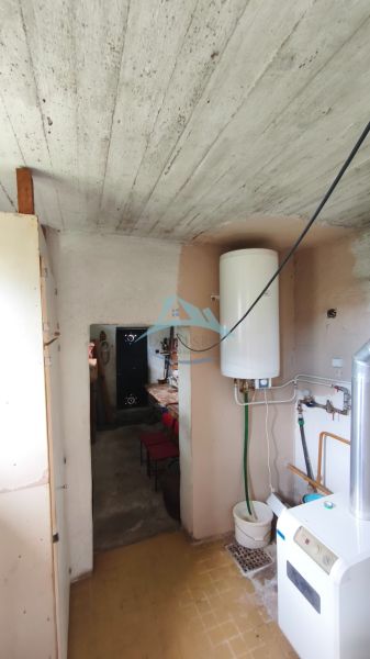 Badezimmer im Einfamilienhaus mit Boiler und Heizraum, Fliesen auf dem Boden.