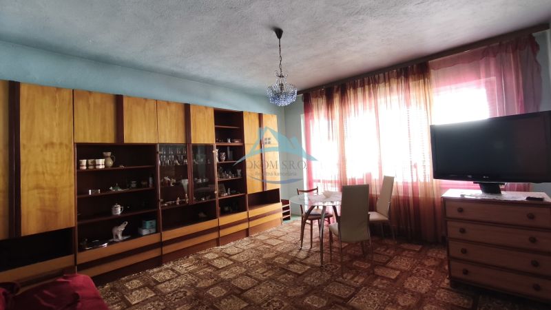Wohnzimmer in einem Einfamilienhaus mit Vitrine, Esstisch und Fernseher.