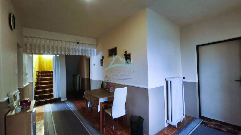 Essbereich mit weißen Stühlen und Treppe im Einfamilienhaus.
