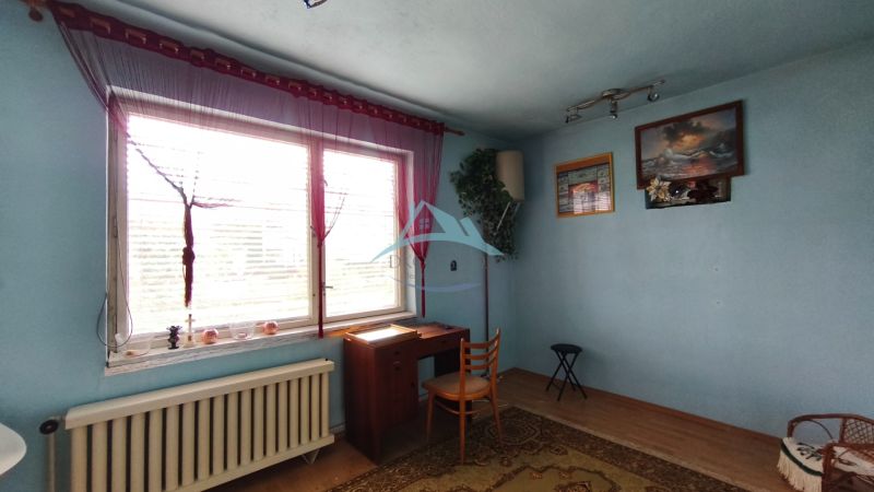 Blaues Zimmer mit Fenster, Tisch und Stuhl in einem Einfamilienhaus.