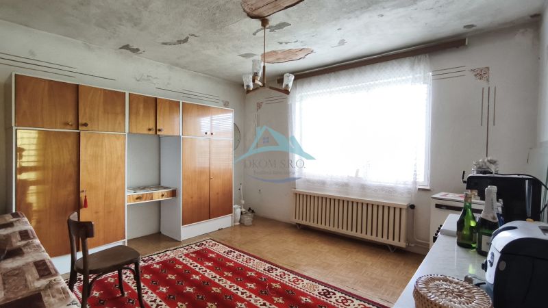 Das Innere eines Einfamilienhauses mit Retro-Möbeln, rotem Teppich und einem großen Fenster.