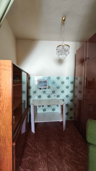 Ein Raum mit einem Spiegel, einem Schrank und Fliesen mit Muster in einem Einfamilienhaus.