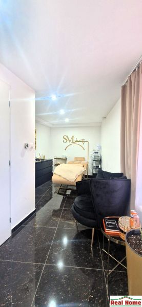 Innenhandelsräume mit Sitzgarnitur, Spiegel und goldenen Accessoires.