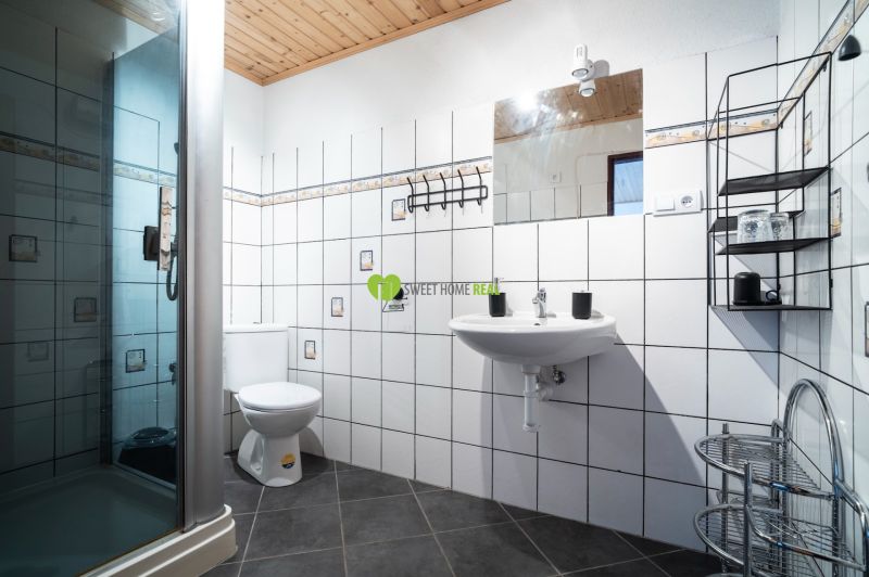 Badezimmer mit Toilette und Duschkabine, Hotels und Pensionen, Fliesen mit dekorativem Muster.