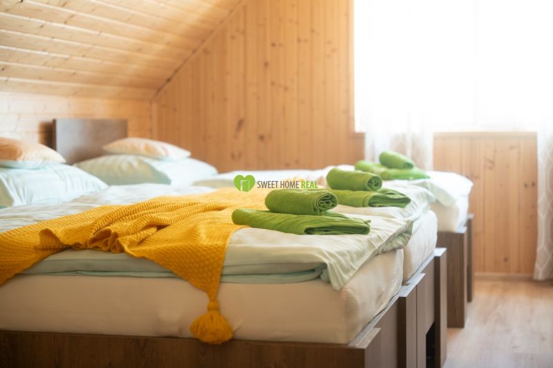 Ein Zimmer mit zwei Betten, einer gelben Decke und Holzvertäfelung in einem Hotel und Pensionen.