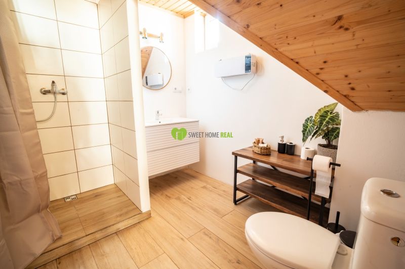 Badezimmer mit Holzboden, Dusche und Waschbecken. Hotels und Pensionen.