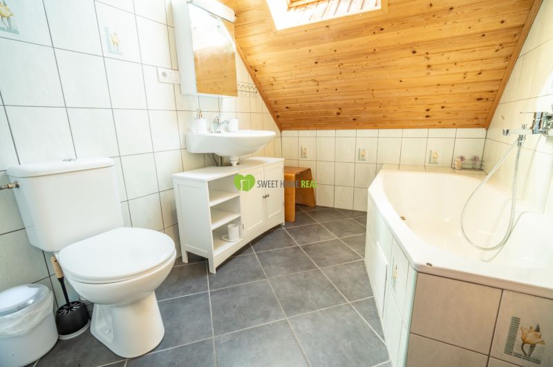 Badezimmer mit Badewanne, Waschbecken und Fliesen in Hotels und Pensionen.