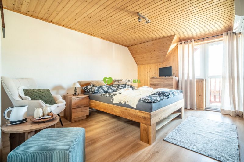 Ein Hotelzimmer mit einem Bett, einem Sessel, einem Teppich und einem Boden mit Holzdekor.
