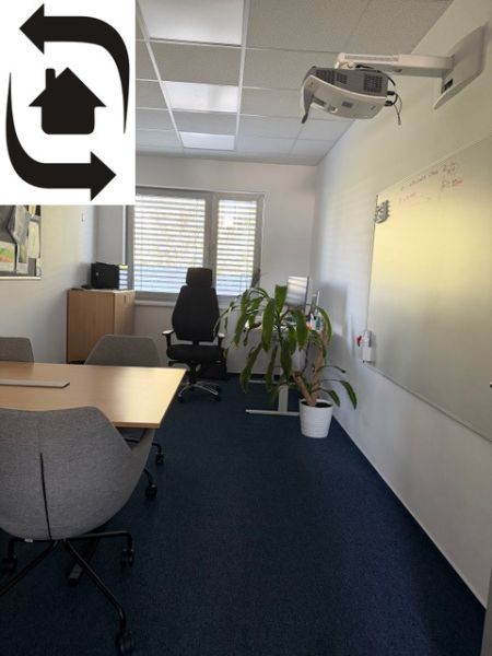Innenraum eines Büros mit einem Whiteboard, einem Konferenztisch und einem Projektor an der Wand des Gebäudes.