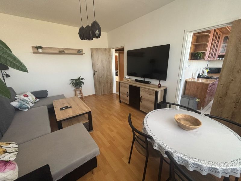 Wohnzimmer in einer 3-Zimmer-Wohnung mit Holzboden und bequemer Couch.