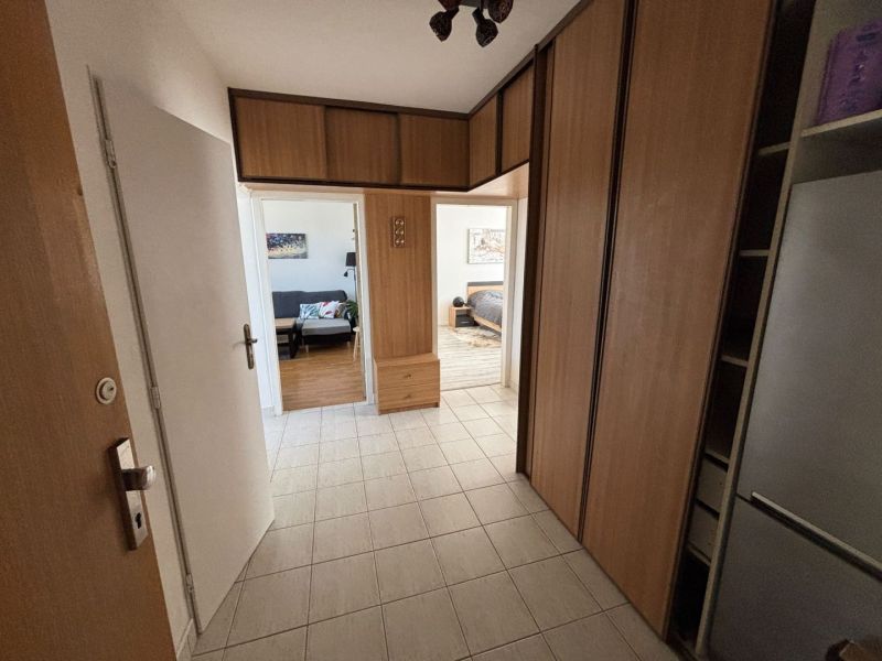 Der Flur in der 3-Zimmer-Wohnung mit Fliesen und einem Einbauschrank.