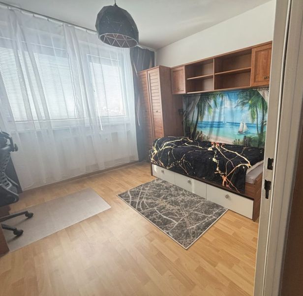 Ein Zimmer in einer 3-Zimmer-Wohnung mit Holzboden und Wanddekoration.