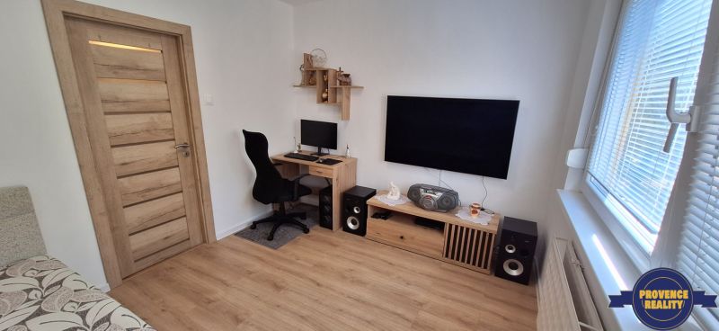 Arbeitsbereich mit Computer und Fernseher, Holzboden in einer 3-Zimmer-Wohnung.