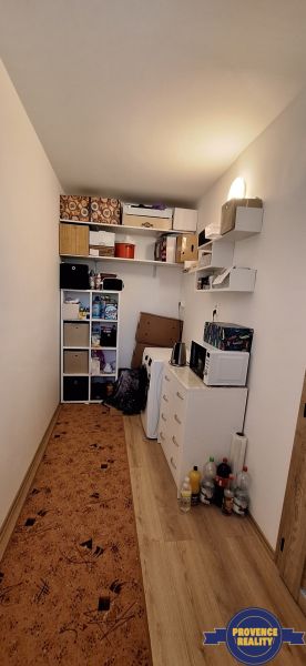 Ein kompakter Raum mit Regalen, einem Schrank und einem Boden in Holzoptik in einer 3-Zimmer-Wohnung.