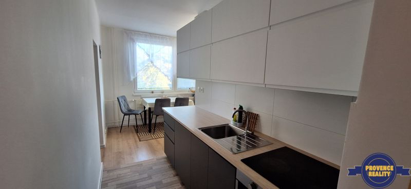 Küche in einer 3-Zimmer-Wohnung, mit Holzboden und Essecke.