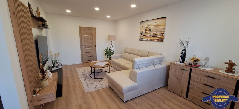 Wohnzimmer in einer 3-Zimmer-Wohnung mit Holzboden und bequemer Couch.