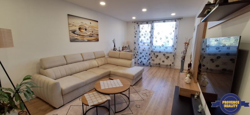 Helles Wohnzimmer mit einer Eckcouch und einem Holzboden in einer 3-Zimmer-Wohnung.