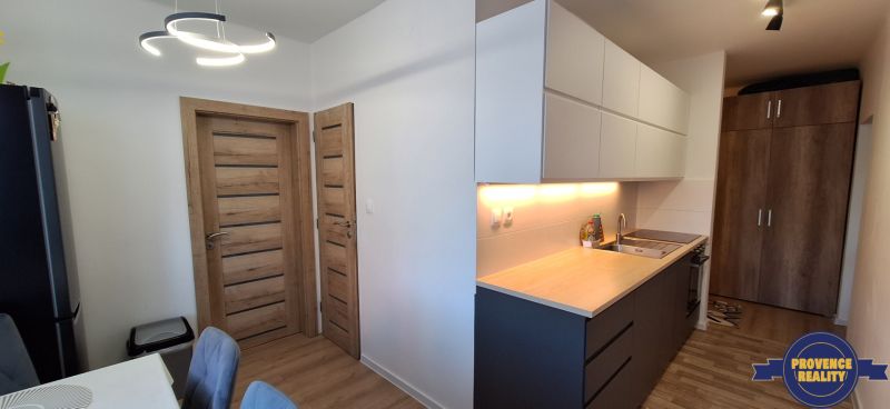 Küche in einer 3-Zimmer-Wohnung mit Holzboden und moderner Beleuchtung.