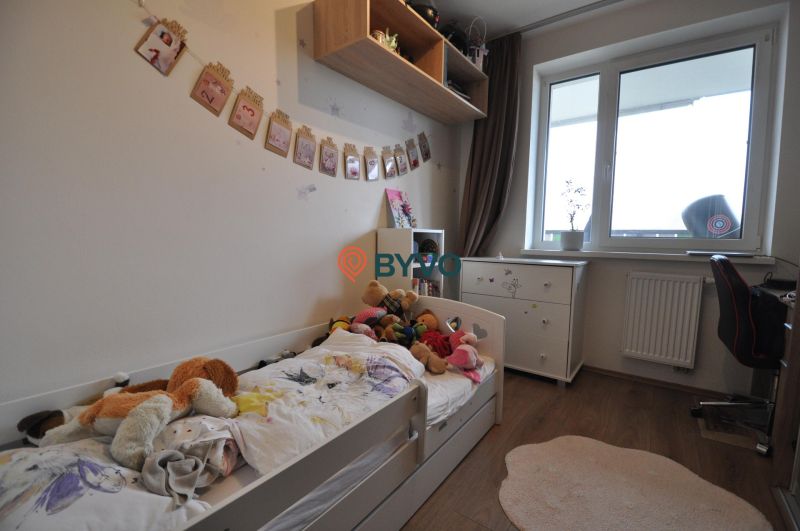 Kinderzimmer in einer 3-Zimmer-Wohnung mit Holzboden und Fenster.