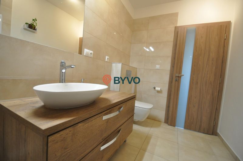 Badezimmer in einer 3-Zimmer-Wohnung mit Waschbecken, Holzboden und Toilette.